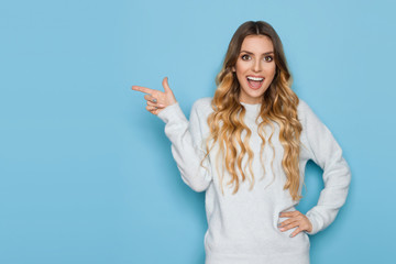 Excited Young Woman In Pastel Sweater Is Pointing And Laughing