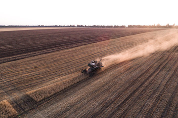 Harvester machine working in field . Combine harvester agriculture machine harvesting golden ripe wheat field. Agriculture. Aerial view. From above.