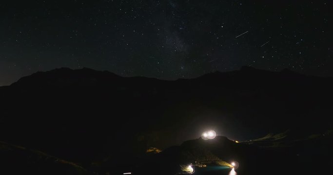 Day to night time lapse from high up on the Alps, Gran Paradiso and Vanoise National Park, Italy France border. Mountain peaks with glaciers, moving clouds and rotating stars in summer.