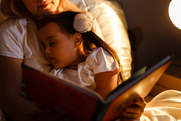 Little daughter fell asleep at mom while reading book