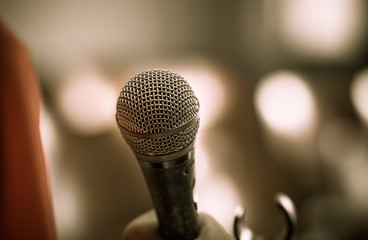 Obraz premium blurred of hands holding businesspeople speech and speaking with microphones in seminar , talking conference hall light with microphones and keynote. Speech is vocalized form of communication humans.