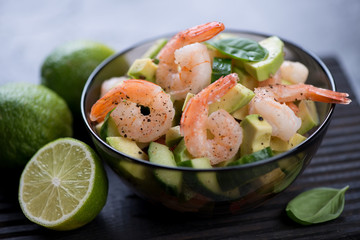 Salad with avocado, cucumber and tiger shrimps, closeup, selective focus, shallow depth of field