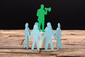 Businessman Speaking Through Megaphone Surrounded By Team