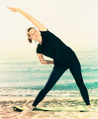 Woman 20-30 years old is practicing stretching in black T-shirt