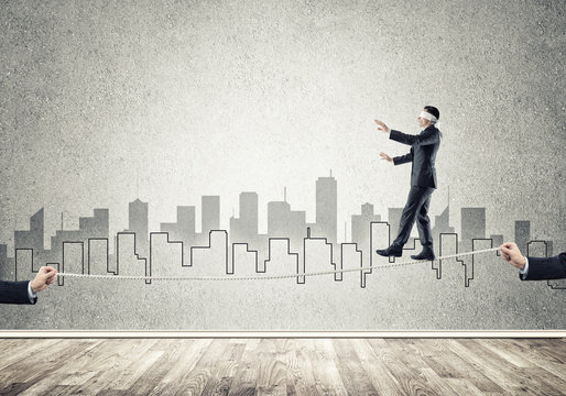 Business concept of risk support and assistance with man balancing on rope