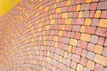 Paving slabs by mosaic close-up. Road paving, construction . Fixed tessellated sidewalk tile. Colored concrete paving slab