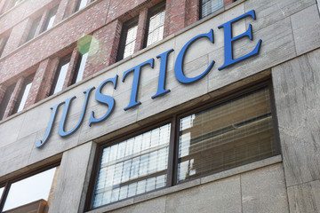 Justice sign on modern building in city