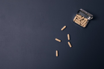 Pills in a metal box on a dark blue background. Medicines, the concept of health. Vitamins! Copy Space.