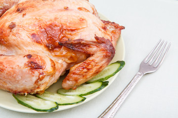Grilled chicken and pieces of cucumber on white plate