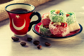 Cup of coffee with coffee beans and Turkish delight on saucer