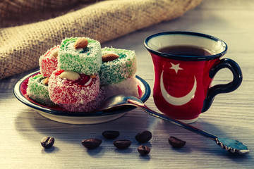 Cup of coffee with coffee beans and Turkish delight on saucer