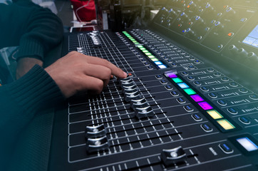 Blurred Hands on the mixing console.