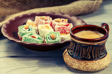 Cup of coffee and Turkish delight on clay plate