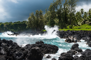 Surf hitting volcanic rocks at the coastline of Maui, Hawaii