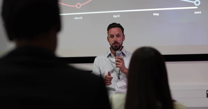 Speaker at a business training conference taking a question