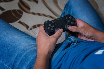 The joystick of the console is close-up in the hands of a man. Man playing on the joystick in a game console