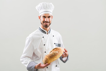 Baker holding bread on gray background.