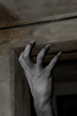 Black hands of the devil on wall background