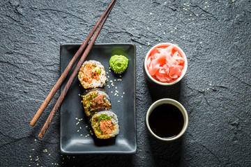 Delicious sushi made of salmon and avocado on black rock © shaiith