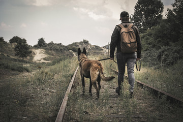  Une femme avec un sac à dos et son chien traversant le chemin de vieux rails dans un monde...