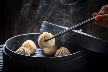 Yummy and hot chinese dumplings on black background - obrazy, fototapety, plakaty