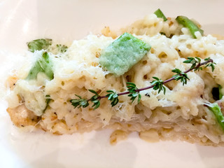 Tasty risotto with fresh herbs vegetables on a white plate