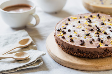 Raw healthy cheesecake, homemade with vegan chocolate. Breakfast table with hot drink