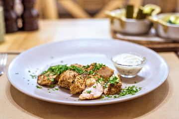Turkey meat stake fillet with parsley on a white plate in a restaurant, delicious dish