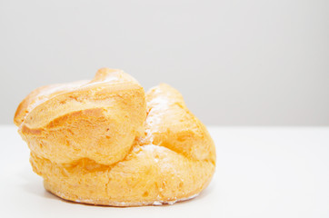 Profiteroles stuffed with pastry cream on white desk in cafe