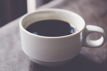 Coffee cup and saucer on a wooden table .