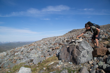 Fototapeta na wymiar Hiker makes a cairn, Haltitunturi, Guolasjávri, summer 