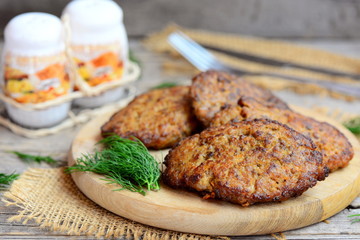 Spicy chicken liver patties with vegetables. Brown fried chicken liver patties on a wooden cutting board. Easy chicken liver recipe idea. Closeup