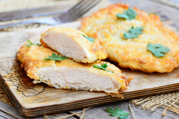 Chicken steaks fried in egg batter. Crispy chicken steaks on a wooden board. Easy chicken breast recipe for dinner. Closeup