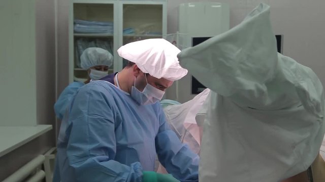 Close-up. Doctor surgeon in protective clothing, performs a gynecological operation