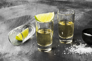 Tequila with lime and salt on a dark background