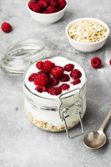 Glanola in glass jar with raspberry on a gray background