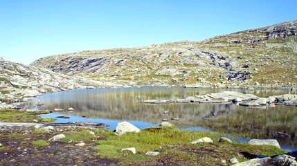 Fototapeta na wymiar View of small lake in the valley between mountains, hiking way to Trolltunga cliff (The Troll's tongue), Odda, Norway