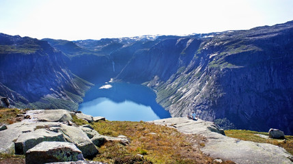 Top view of lake between mountains, picturesque landscape, beauty in nature, hiking way to Trolltunga cliff (The Troll's tongue), Odda, Norway