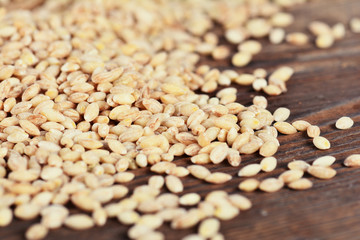 Pearl barley grain seed on wooden background