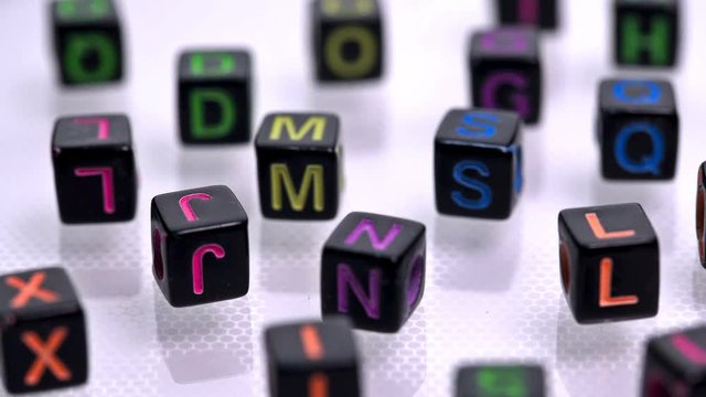 black blocks with colored letters scattered on a white background