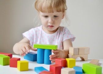 Caucasian Girl Playing with Wooden Colorful Cubes at Home Early Education Preparing for School Development