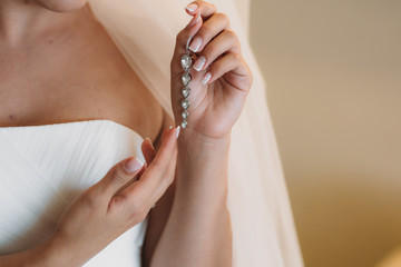 Earrind in the hands of the bride. Concept of jewelry