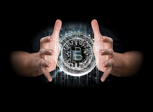 A pair of male hands enveloping a hologram of a bitcoin on an isolated dark background