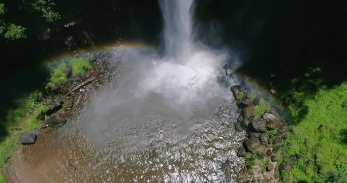 Woman Floating in Waterfall Pool Rising Aerial Shot