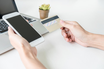 Happy Woman using smart phone and credit card register payments online shopping and customer service network connection market, using technology on laptop, Internet Online shopping or banking concept