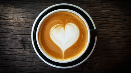 Cup of Latte art with heart shape on old wooden background,top view , mobile phone photography