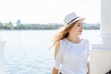 Portrait of a beautiful young blonde girl in hat, outdoors