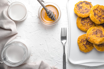 Honey, pumpkin pancakes, hemp milk on a white table frame