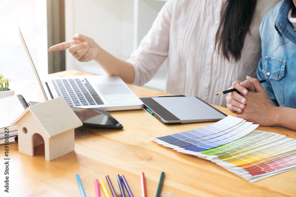 Aufkleber young colleagues designers working together on a creative project and color samples for selection, c