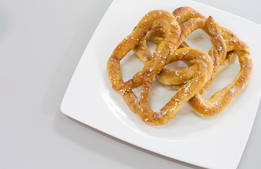 Pretzel bread white sesame in white dish on gray background